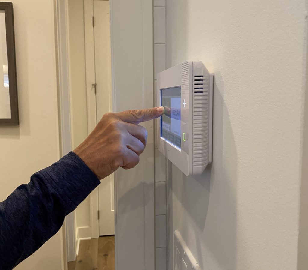 a-man-is-setting-his-alarm-on-a-security-panel-in-his-smart-home-.jpg